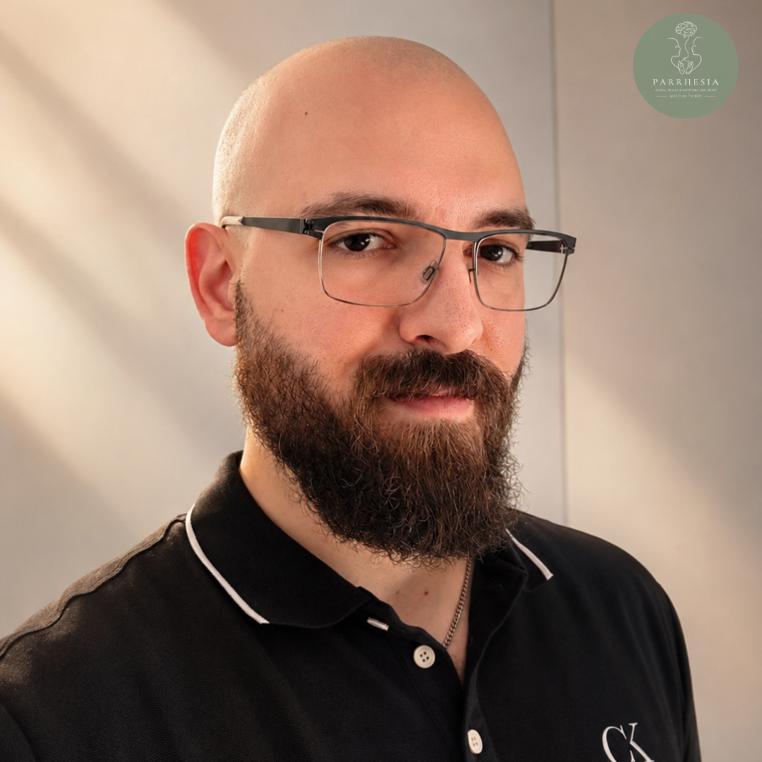 Michali Charalampous, psychologist at Parrhesia Cyprus, professional headshot portrait with glasses and beard, specialising in mental health support, counselling, and emotional wellbeing services in Cyprus.